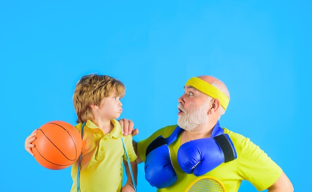 Temps de famille grand-père et petit-fils s'entraînant ensemble sport familial vieil homme avec des gants de boxe garçon détient