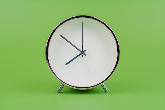 Photo temps immobile photo de l'aiguille de l'heure d'une horloge en mouvement sur un fond vert concept de temps