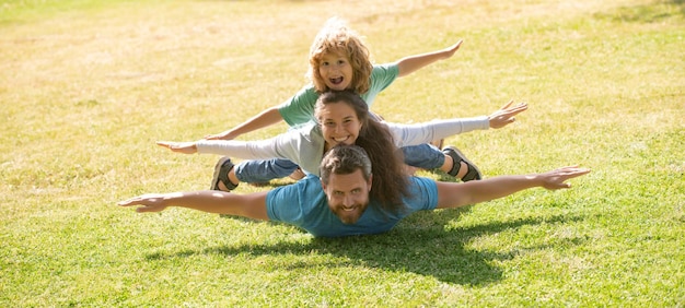 Temps de loisirs en famille famille allongée sur l'herbe dans le parc parents donnant à l'enfant des ferroutages dans le parc