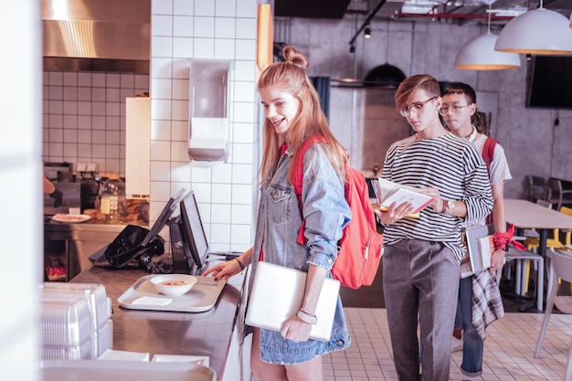 Le temps de manger. Belle fille exprimant la positivité en attendant le dîner