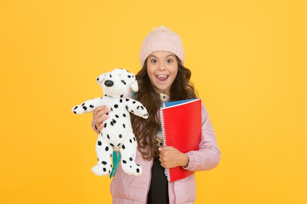 Temps de pause et de détente. bonheur d'enfance. garde et développement des enfants. livres de soins pour enfants. la vie quotidienne des élèves. retour à l'école. petite fille heureuse tenir chien jouet. vacances d'hiver et vacances.