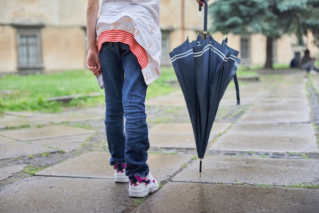 Temps pluvieux, jambes de fille avec un parapluie