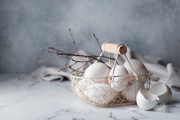 Temps de printemps vacances de pâques oeufs blancs dans un panier fond gris