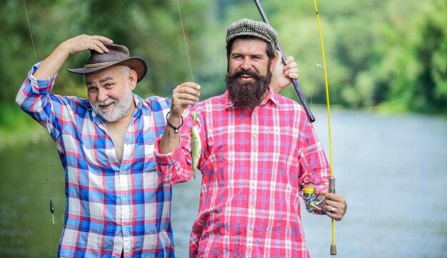 En temps de repos. amitié masculine. liens familiaux. père et fils à la pêche. deux pêcheurs heureux avec des cannes à pêche. week-end d'été. pêcheur d'hommes mûrs. loisir et activité sportive. Appât à truite.