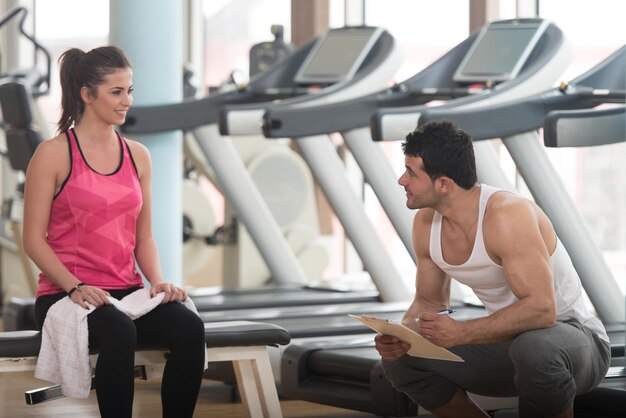 Temps de repos Jeune homme musclé confiant se reposant dans une salle de sport saine après l'exercice