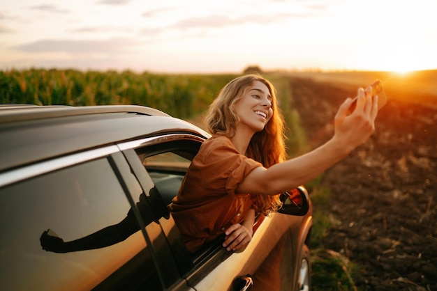 Temps de selfie Une femme se fait un selfie en voiture pendant un voyage en voiture Style de vie Voyage tourisme vie active