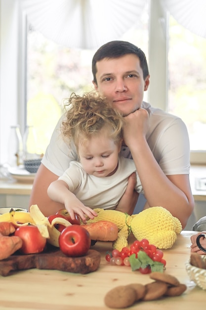 Le temps des vitamines. Jolie petite fille et son beau père prenant son petit déjeuner à la table de la cuisine.