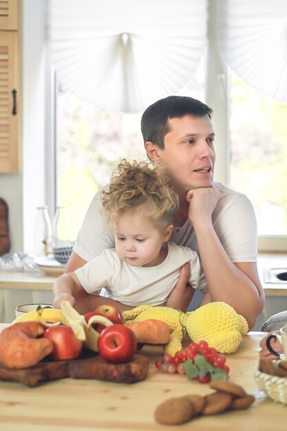 Le temps des vitamines. Jolie petite fille et son beau père prenant son petit déjeuner à la table de la cuisine.