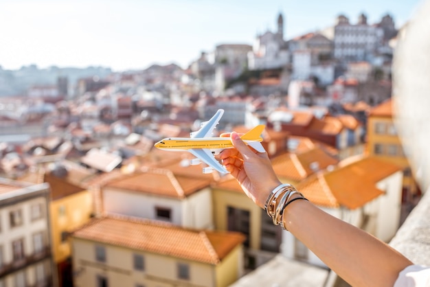 Tenant un avion jouet sur le fond du paysage urbain de Porto. Voyager en avion dans le concept de Porto
