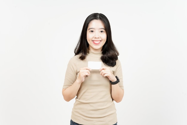 Tenant une carte bancaire vierge ou une carte de crédit d'une belle femme asiatique isolée sur fond blanc