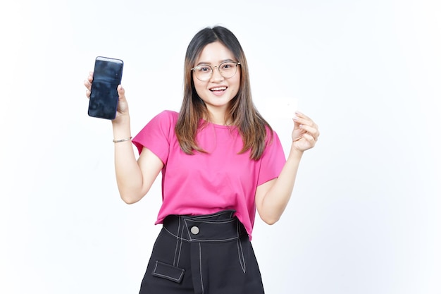 Tenant une carte bancaire vierge et un smartphone à écran vide d'une belle femme asiatique isolée sur blanc
