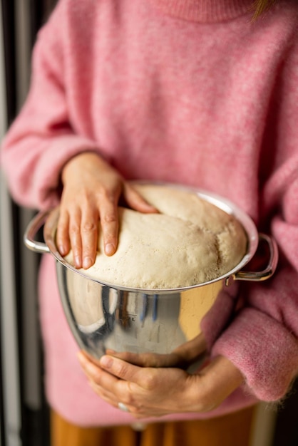 Photo tenant une cruche avec de la pâte levée