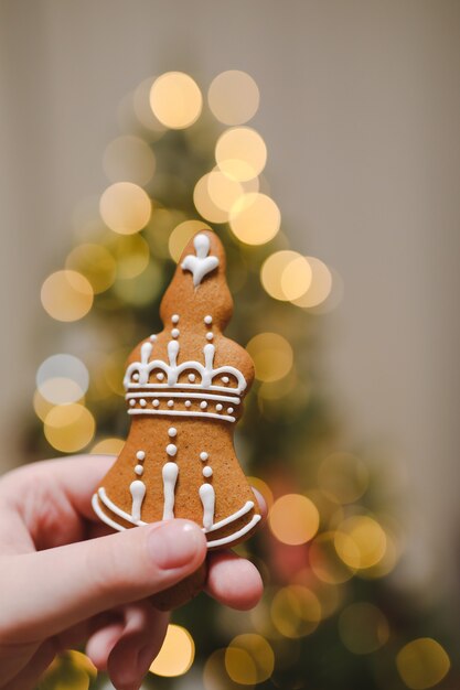 tenant un jouet de Noël dans une main et décorant un sapin de Noël