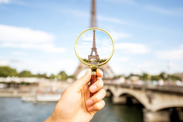 Tenant une loupe axée sur la tour Eiffel à Paris