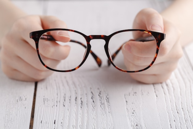 Tenant des lunettes dans des mains féminines