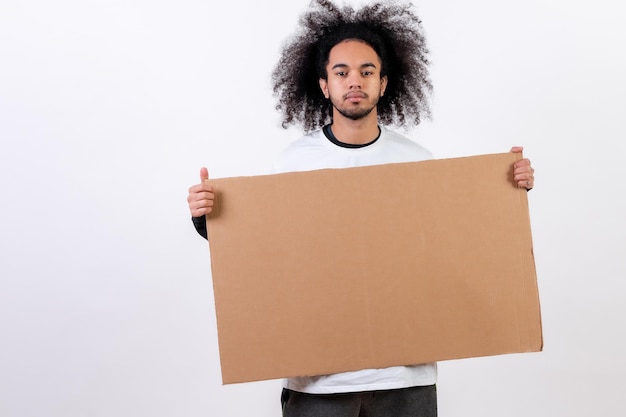 Tenant une pancarte avec espace de copie et de collage Jeune homme aux cheveux afro sur fond blanc