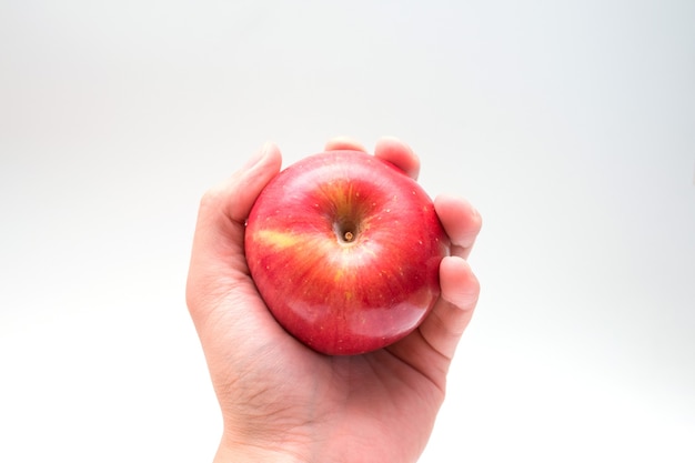 Tenant une pomme dans la main d'en bas isolé sur fond blanc