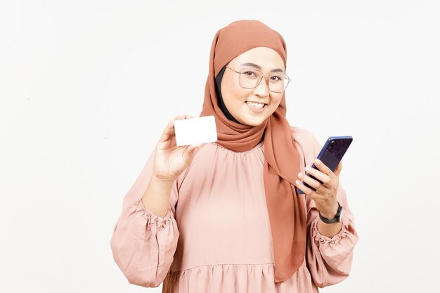Tenant un smartphone et une carte bancaire vierge de belle femme asiatique portant le hijab