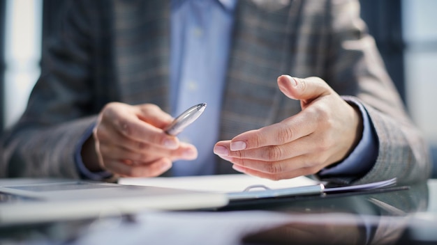 Tenant un stylo à la main signant un document juridique homme d'affaires signant un contrat à table