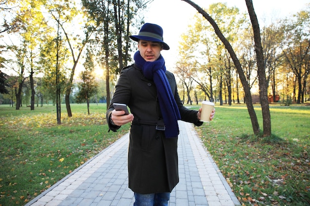 Tendance beau jeune homme à la mode automne debout en milieu urbain.