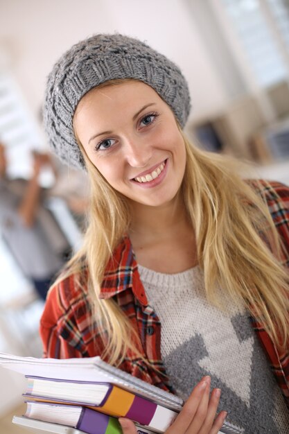 Tendance étudiante tenant des livres scolaires