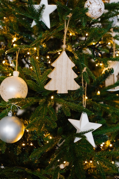 Photo tendance des jouets d'arbre de noël élégants sur l'arbre de noël avec des lumières en gros plan et une mise au point sélective