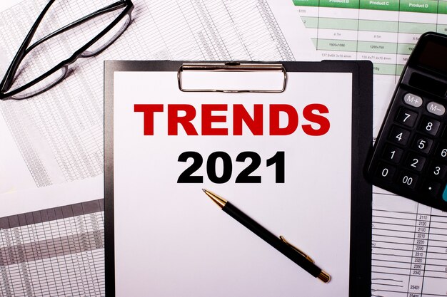 Photo tendances 2021 est écrit sur une feuille de papier blanc, près des lunettes et de la calculatrice.