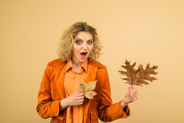 Tendances de la mode pour la chute des feuilles d'automne femme automne avec des feuilles dorées surprise jeune fille avec l'automne