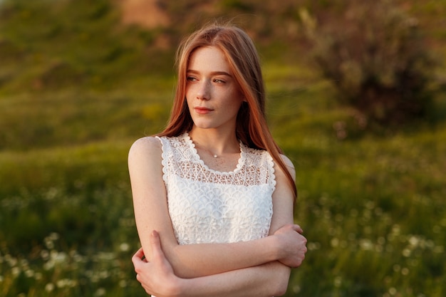 Tendre femme au gingembre en robe de dentelle blanche