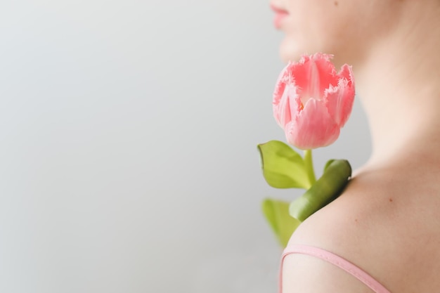 tendre portrait romantique d'une jeune femme avec des tulipes fraîches roses