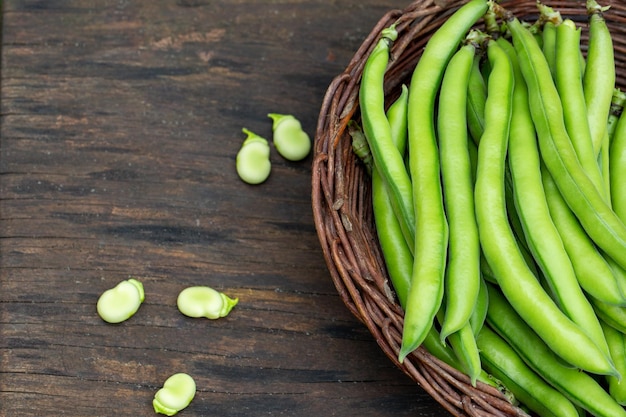 tendres fèves dans un panier sur bois Alimentation saine et biologique