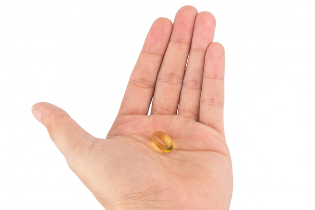 Tenez l&#39;huile de poisson en train de manger des capsules d&#39;huile de poisson en isolement sur fond blanc