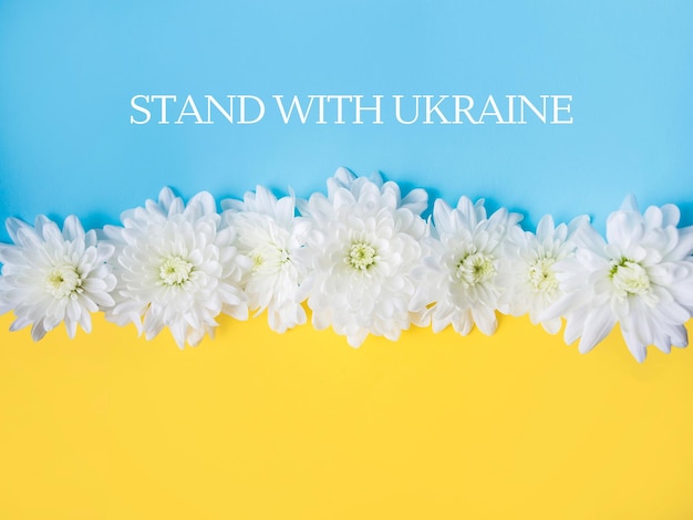 Tenez-vous avec l'Ukraine écrit sur fond bleu et jaune.