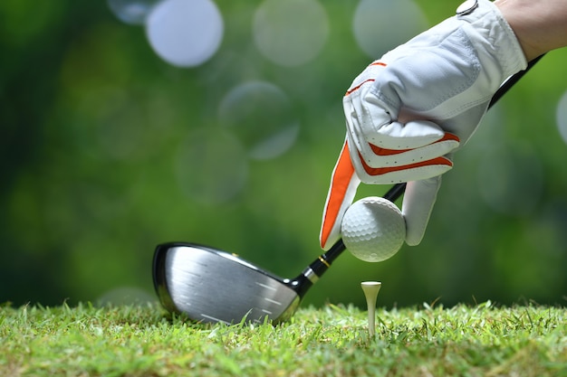 Photo tenir la balle de golf avec tee sur le parcours de golf