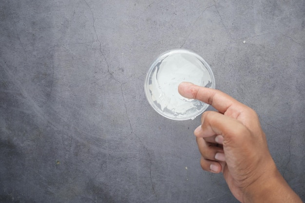 Tenir à la main un pot de gel pour les cheveux