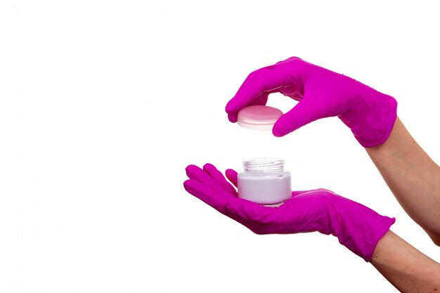 Tenir les mains cosmétiques vieille personne tube gel rose médical gant blanc isolé pot de crème