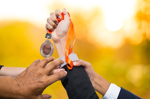 Tenir les médailles du gagnant après avoir réussi avec son entreprise.