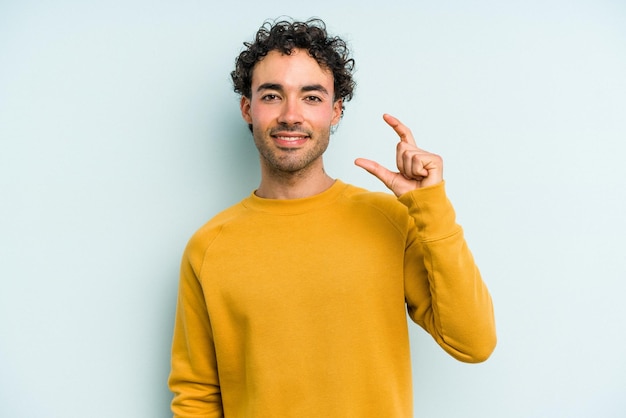 Tenir quelque chose de petit avec les index souriants et confiants