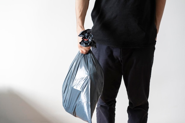 Tenir un sac poubelle en plastique sortir la poubelle