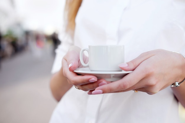 Tenir une tasse de café dans le lieu en plein air ou sur le pont d'observation.