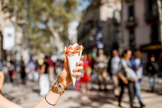 Tenir la viande séchée espagnole traditionnelle jamon à l'extérieur dans la rue à Barcelone