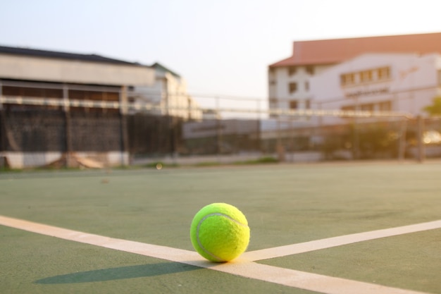 Photo tennis sur la ligne de cours avec des fusées éclairantes de la lumière du soleil dans les sports