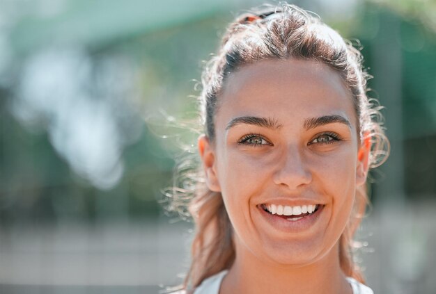 Photo tennis sportif et portrait de visage d'une femme sur un terrain extérieur prêt pour l'exercice de fitness et l'entraînement motivation bonheur et fille debout sur un court de tennis pour s'entraîner et jouer au jeu