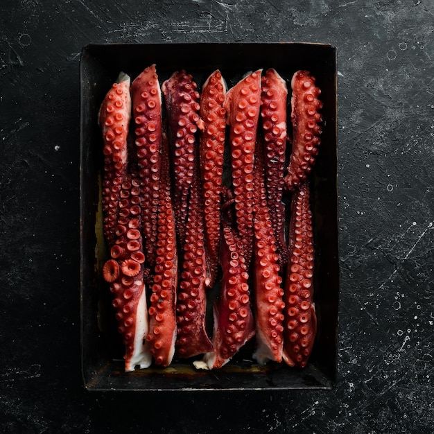 Tentacules de poulpe bouillies avec des épices et des herbes dans un plat de cuisson en métal Vue de dessus Mise à plat