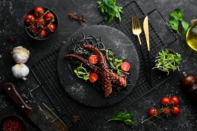 Tentacules de poulpe cuits dans une sauce à l'ail et des pâtes noires à l'encre de seiche Restaurant de luxe Cuisine de style rustique de fruits de mer Mise à plat