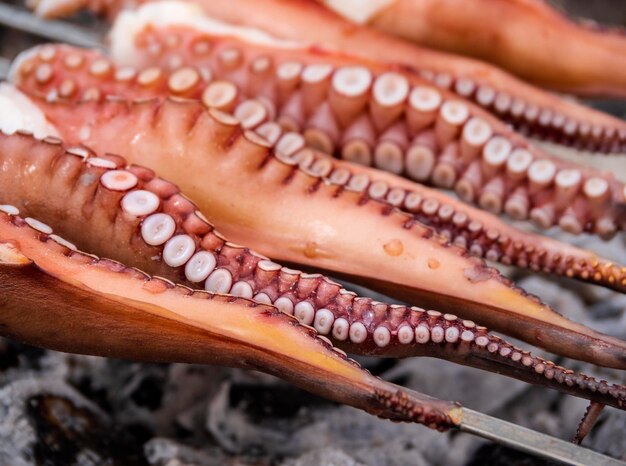 Tentacules de poulpe avec ventouses sur le gril en gros plan sur l'île grecque de Grèce