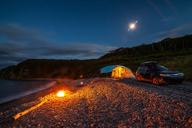 Tente de camping au bord de la mer dans la nuit