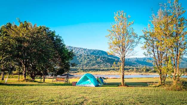 Tente de camping tente pyramide en bleu parmi la nature forestière avec la montagne contre le ciel bleu en arrière-plan à Khaoyai Thaïlande