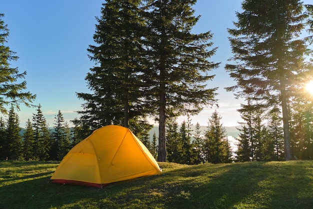 Tente de camping touristique sur camping de montagne lors d'une soirée ensoleillée Concept de tourisme actif et de randonnée