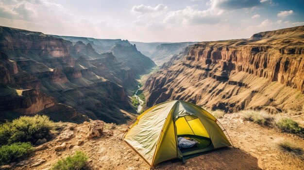Une tente est installée sur une falaise surplombant un canyon.